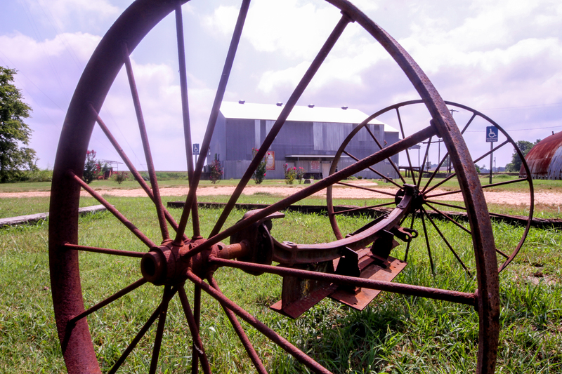 ETHIC Museum and Glendora Cotton Gin, seen through farming implement. 2015